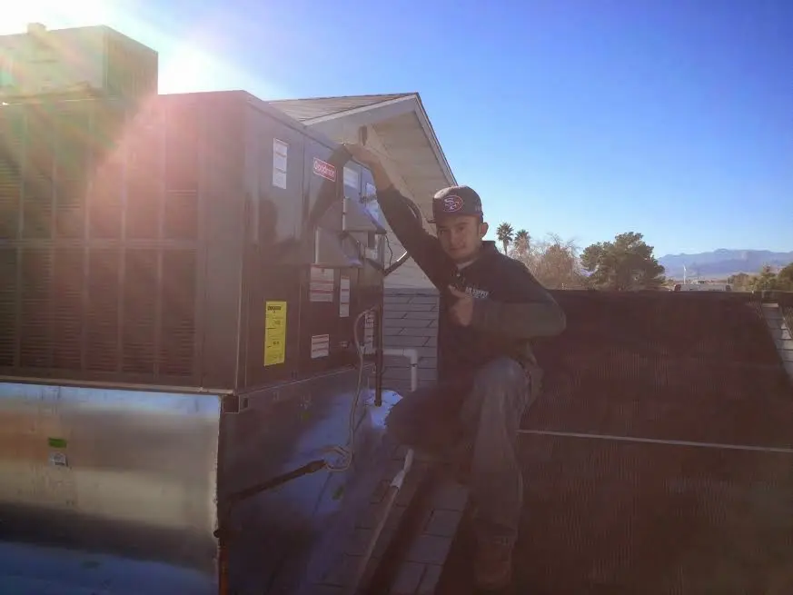HVAC technician performing Boiler Repair on a rooftop unit in Utica